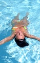 Attractive, fit woman floating in swimming pool Royalty Free Stock Photo