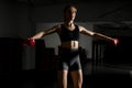 Attractive fit woman works out with dumbbells as a fitness conceptual over dark background Royalty Free Stock Photo