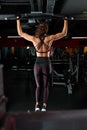 Attractive fit woman works out with dumbbells as a fitness conceptual over dark background. Royalty Free Stock Photo