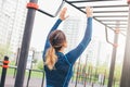 Attractive fit young woman in sport wear girl pulls up on the bar at street workout area. The healthy lifestyle in city Royalty Free Stock Photo