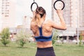 Attractive fit young woman in sport wear girl pulls up on the rings at street workout area. The healthy lifestyle in Royalty Free Stock Photo