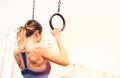 Attractive fit young woman in sport wear girl pulls up on the rings at street workout area. The healthy lifestyle in Royalty Free Stock Photo