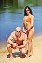 Attractive fitness couple posing on a beach