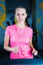 Attractive fitness girl running on machine treadmill. Pretty girl doing workout at modern fitness gym. Royalty Free Stock Photo