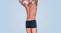 Attractive fitness male model in black underwear showing his abdominal torso on a blue background. Image of sporty handsome strong Royalty Free Stock Photo
