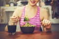 Attractive fitness woman is eating salad with healthy glass of juice