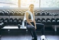 Attractive fitness woman sitting and drinking water in gym,Asian female break and relex after workout Royalty Free Stock Photo