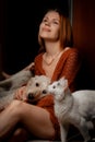 Attractive forty year old woman with a white cat and dog. Pets care concept Royalty Free Stock Photo