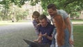 Four students laugh at what they see on laptop on campus Royalty Free Stock Photo