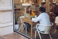 Attractive freelancers sitting at table in cafe and writing in notebook Royalty Free Stock Photo