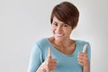 Attractive, friendly, smiling woman giving two thumbs up