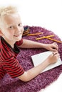 Attractive friendly young boy lying on a rug