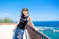 Attractive funky girl on top of docks, seaside view. Royalty Free Stock Photo