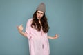 Attractive funny amusing positive cute nice adorable tender young curly brunette woman wearing pink shirt and gray hat