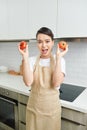 Attractive funny house wife lady arms holding two big tomato playful mood enjoy morning cooking tasty dinner wait family guests Royalty Free Stock Photo