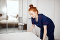 A female chambermaid making bed in hotel room Royalty Free Stock Photo