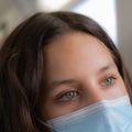 Attractive girl with grey eyes wearing a surgical mask half face closeup shot Royalty Free Stock Photo