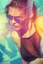 Attractive girl in bikini and sunglasses in pool Royalty Free Stock Photo