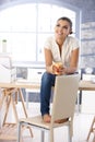 Attractive girl daydreaming on top of desk smiling