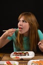 Attractive girl eating rolls at the table