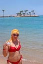 Girl enjoying relax drinking coffee on beach. Woman relaxing standing in sea Royalty Free Stock Photo