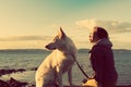 Attractive girl with her pet dog at a beach, colorised image