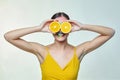 Attractive girl holds orange slices in front of her face Royalty Free Stock Photo