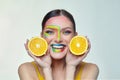 Attractive girl holds orange slices in front of her face Royalty Free Stock Photo