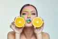 Attractive girl holds orange slices in front of her face Royalty Free Stock Photo