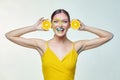 Attractive girl holds orange slices in front of her face Royalty Free Stock Photo