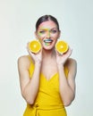 Attractive girl holds orange slices in front of her face