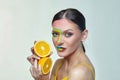 Attractive girl holds orange slices in front of her face Royalty Free Stock Photo