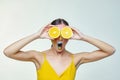 Attractive girl holds orange slices in front of her face Royalty Free Stock Photo