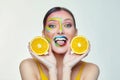 Attractive girl holds orange slices in front of her face Royalty Free Stock Photo