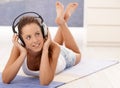 Attractive girl listening music laying on floor Royalty Free Stock Photo