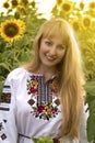 Girl with long hair in Ukrainian clother posing among the bales in the field