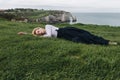 attractive girl lying on green grass on cliff Etretat Royalty Free Stock Photo