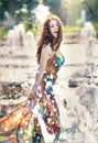 Attractive girl in multicolored short dress playing with water in a summer hottest day. Girl with wet dress enjoying fountains Royalty Free Stock Photo