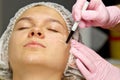 Attractive girl patient with instructions on her face for plastic surgery operation. Surgeon touching a person`s face. The concep Royalty Free Stock Photo