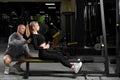 Attractive girl with a personal trainer working out in a gym. Fitness instructor conducts personal training