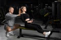 Attractive girl with a personal trainer working out in a gym. Fitness instructor conducts personal training