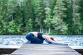 Attractive girl practicing yoga, sitting in Child exercise, Balasana pose on the lake. The concept of appeasement, healthy