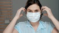 Attractive girl puts on surgical mask on her face. Cold, flu, virus, acute respiratory infections, quarantine, epidemic, irony,