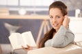 Attractive girl reading book on sofa at home Royalty Free Stock Photo