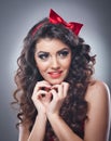 Attractive girl with a red bow on her head and red bra send a kiss.Pinup model on grey background.Beautiful pinup model Royalty Free Stock Photo