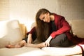 Attractive girl in a red coat having a rest on the sofa Royalty Free Stock Photo