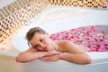 An Attractive girl relaxing in bath with rose petals Royalty Free Stock Photo