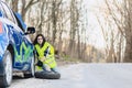 attractive girl remove wheel from car at road alone