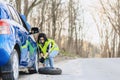 attractive girl remove wheel from car at road alone