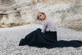 attractive girl sitting on shore near cliff Etretat Royalty Free Stock Photo